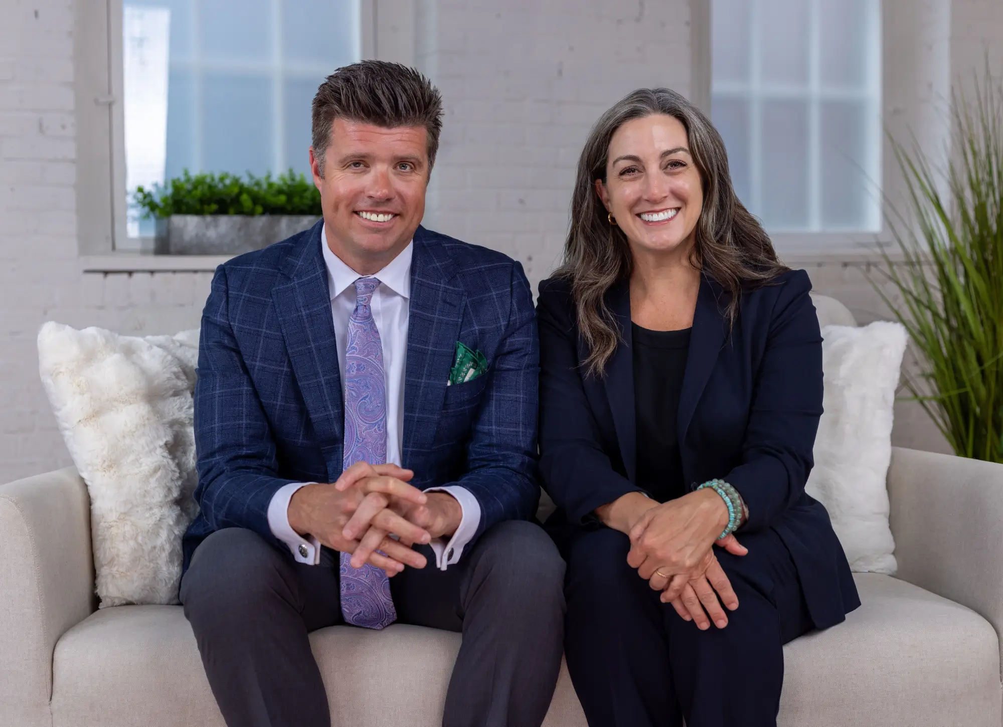 Sam Surface and Rebecca Waxse seated together, smiling in a professional office setting for their judge campaign.